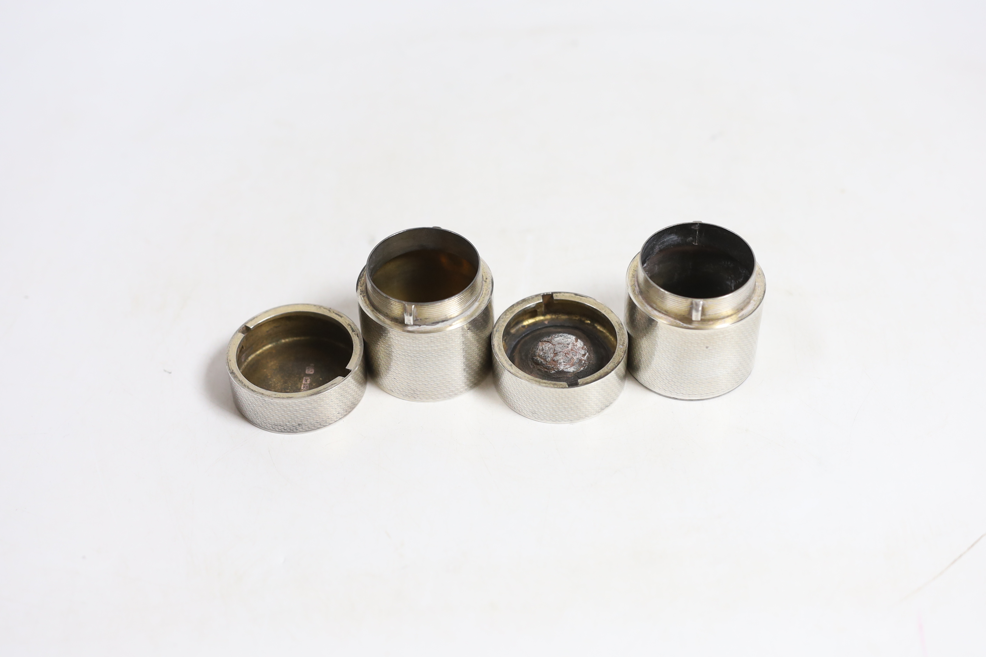 A George V engine turned silver cylindrical travelling inkwell?, by Samson Mordan & Co, London, 1910 with ribbed base and one other similar cylindrical box and cover, same date and maker, both with engraved crest, 48mm a